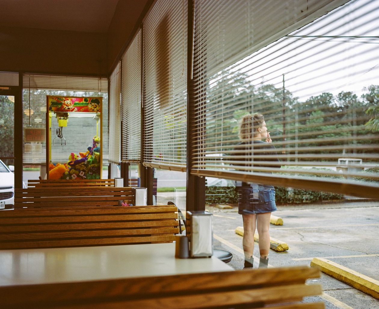 woman sitting in a cafe and looking through the blinds. New Orleans, Louisana