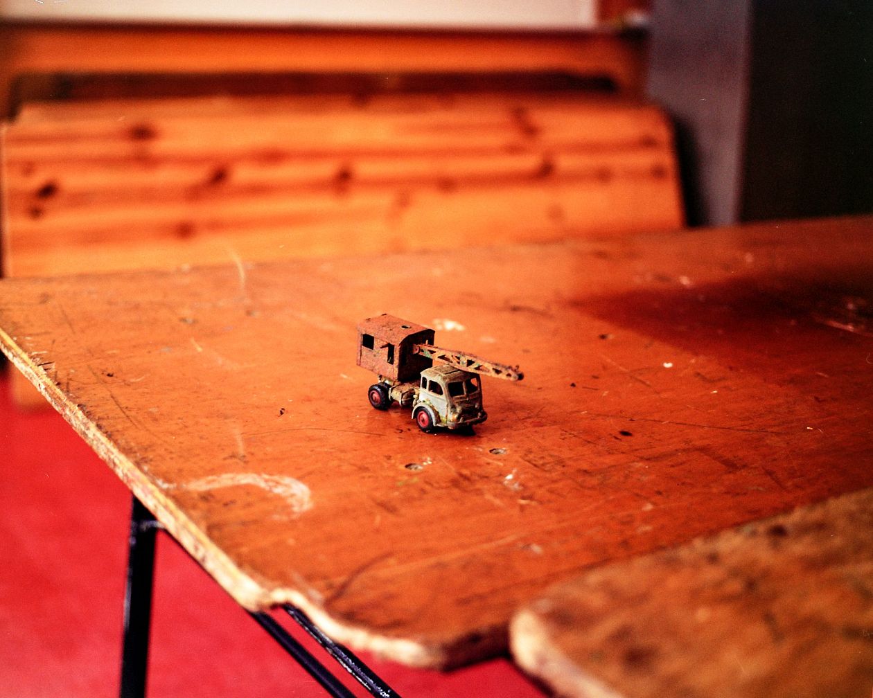 Model of a toy car on an old wooden table in a room