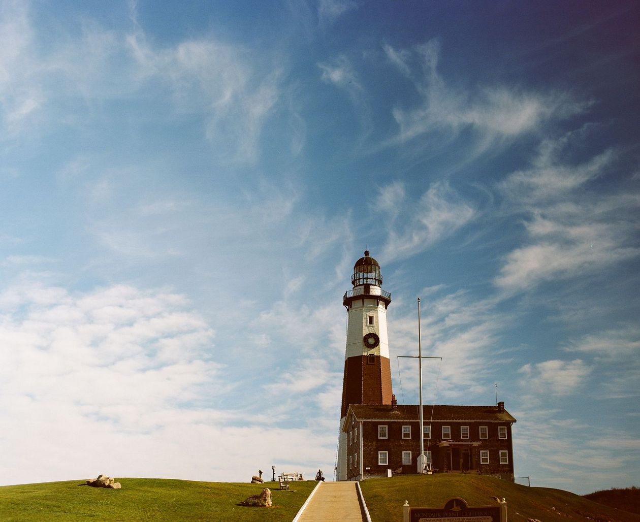 Lighthouse on a hill with blue sky and clouds in the background, Montauk, USA