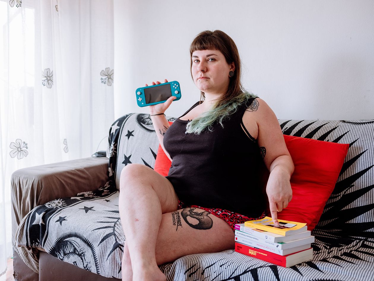 woman with tattoos on her body sits on a sofa