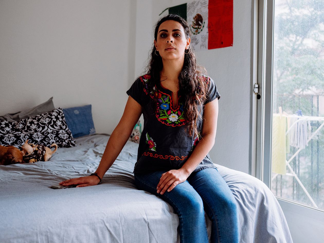 Portrait of a mexican woman sitting on the bed at home