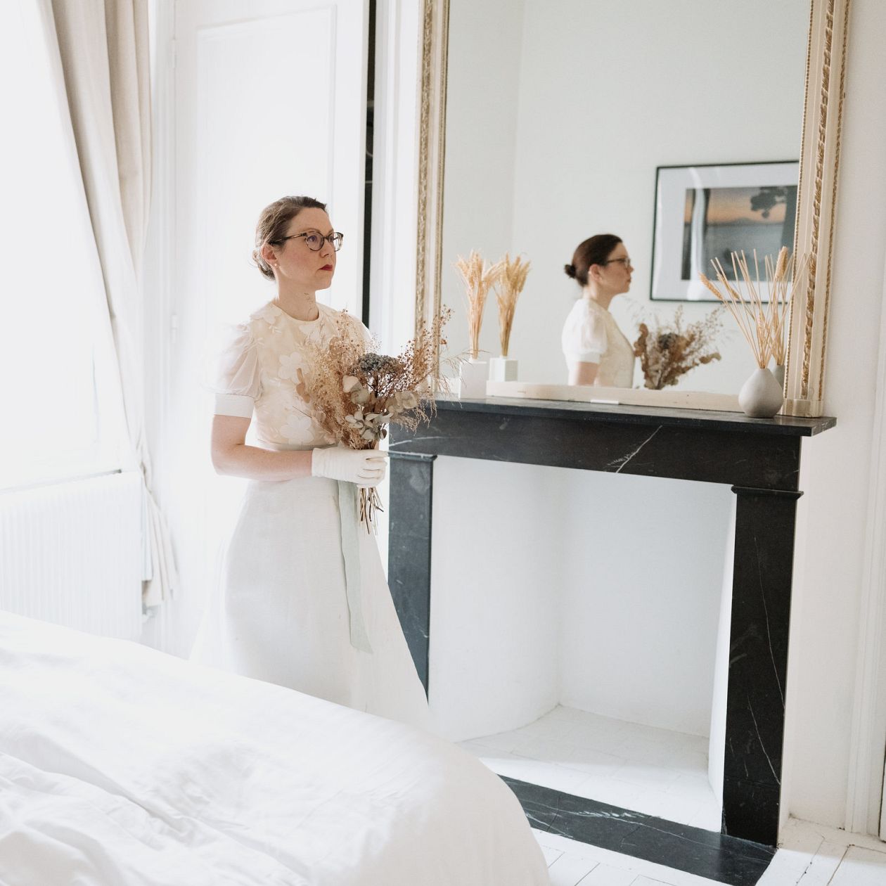 Beautiful bride in white wedding dress posing in her bedroom at morning.