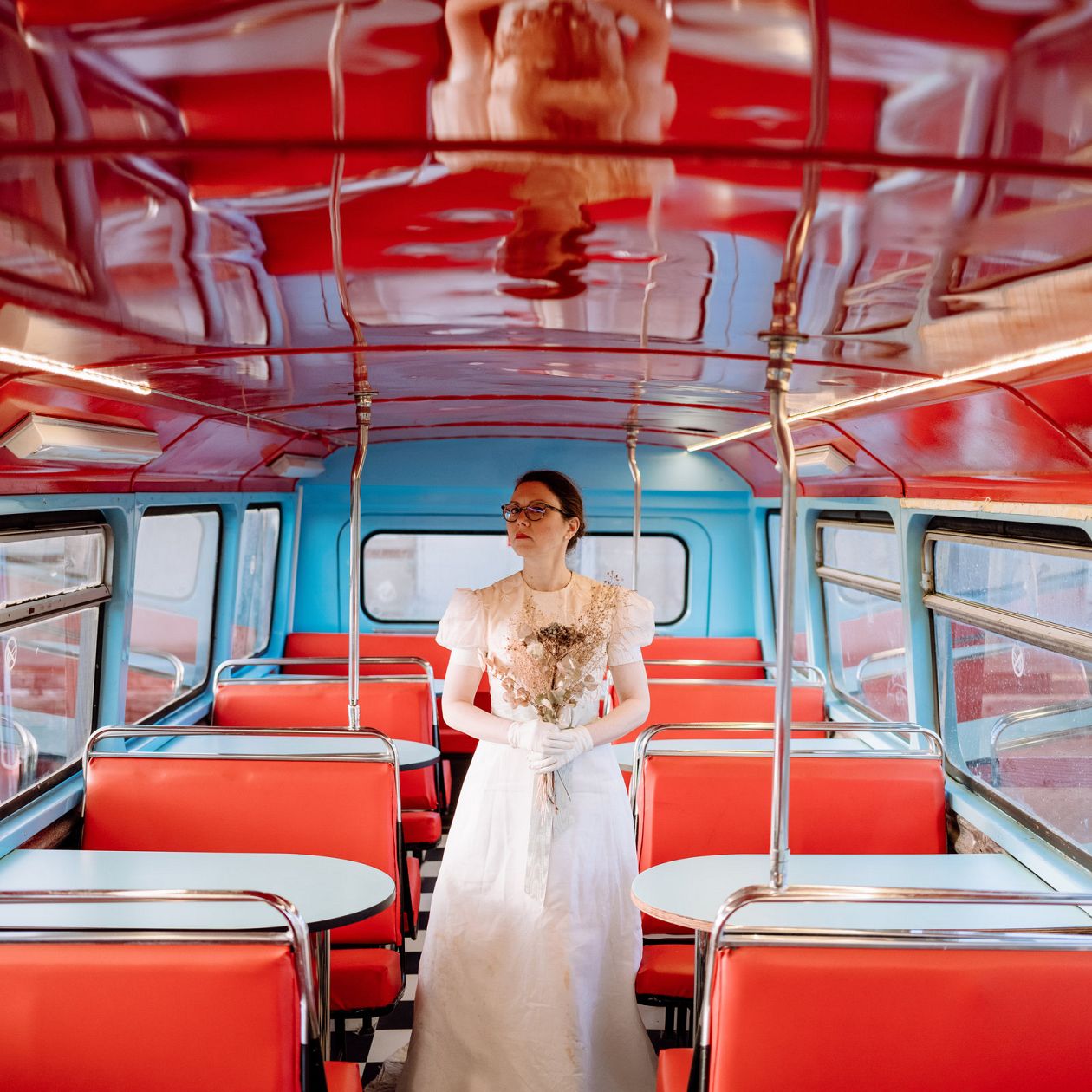 Wedding day. Beautiful bride in white wedding dress and veil posing in a bus.